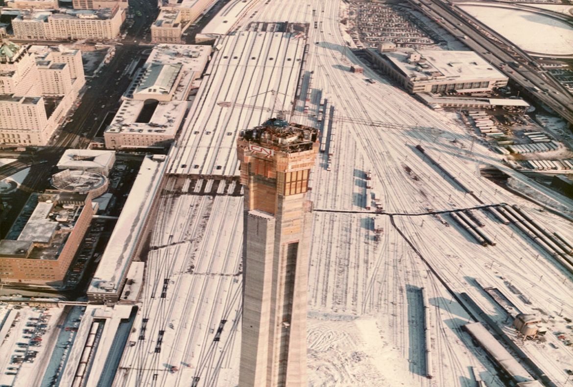 An aerial view of the CN Tower construction site facing east, with the surrounding railyards covered in snow in December 1973.