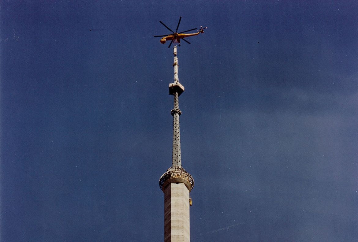 A Sikorsky helicopter named Olga lowers the antenna onto the top of the CN Tower in March 1975.