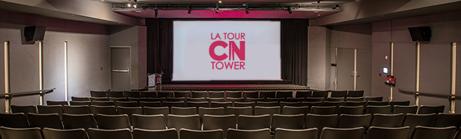 The interior of the Maple Leaf Cinema. Rows of seating face a movie screen displaying the CN Tower logo