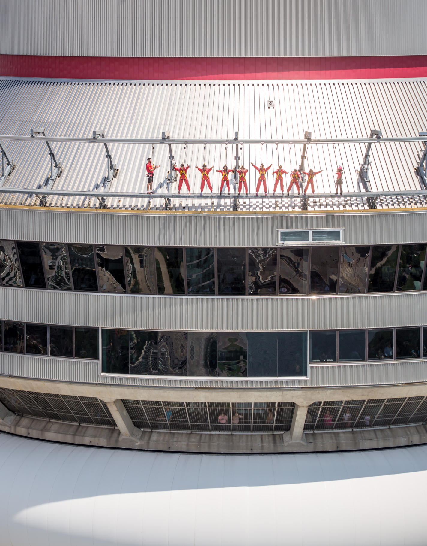 Group of people leaning over the edge walk as viewed from the eye level.