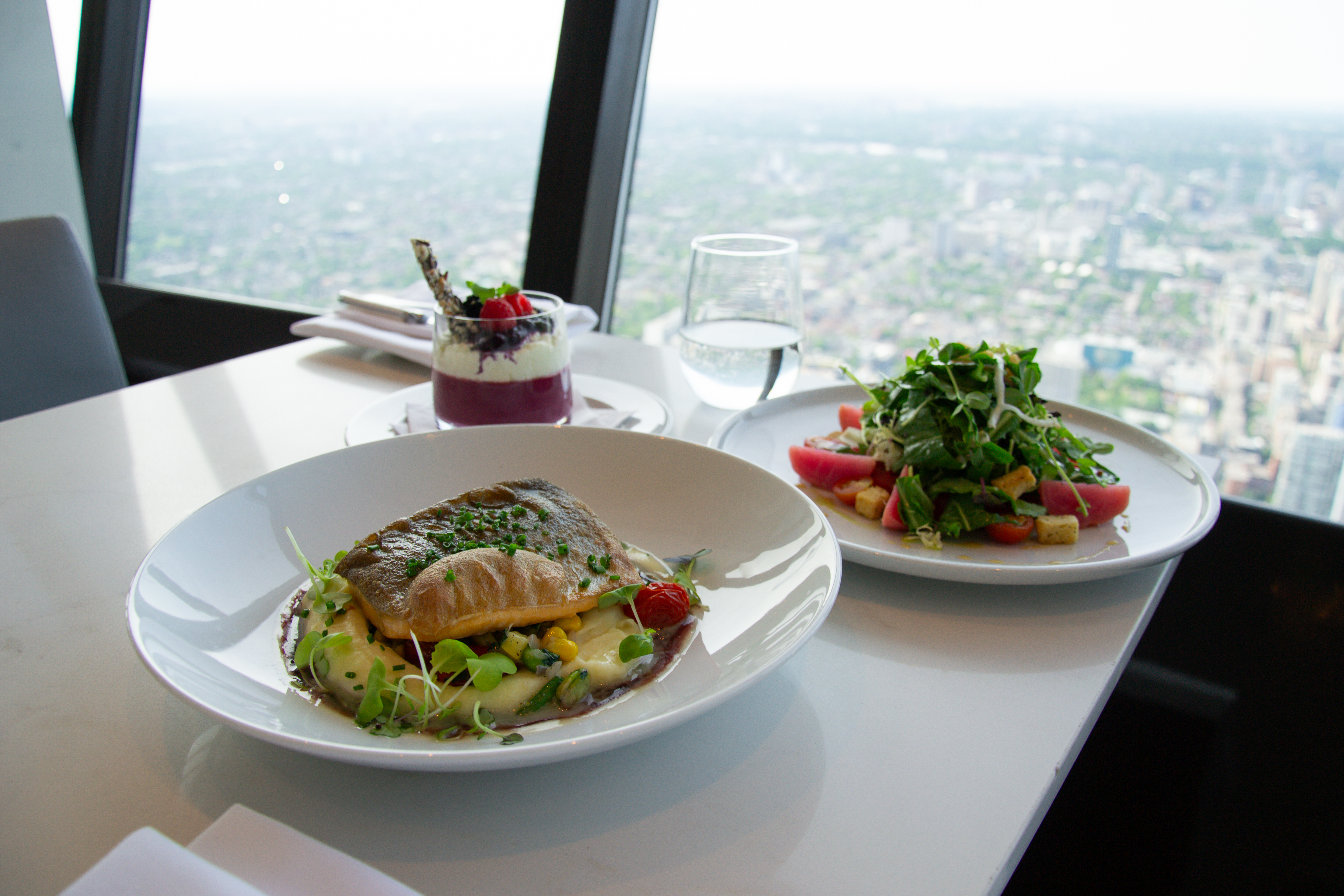 The entire Indigenous menu on a table at 360 overlooking the view of the city of Toronto.