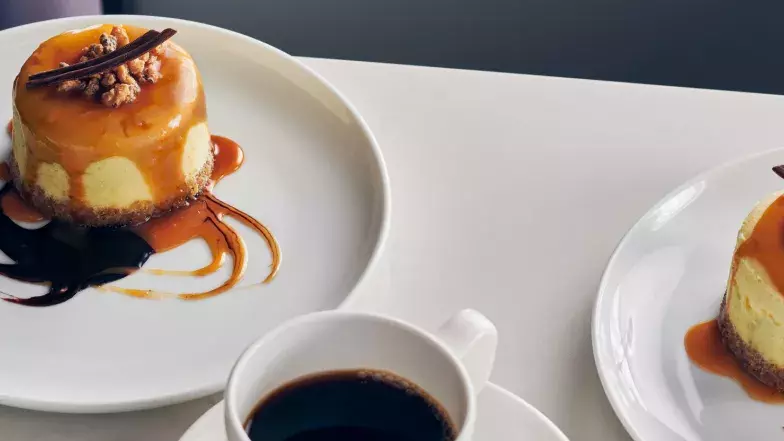 Two servings of maple cheesecake, drizzled with chocoate and caramel sauce