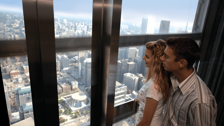 couple in an elevator at the cn tower looking at the view