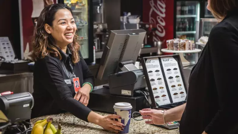 employee greeting a customer at le Café