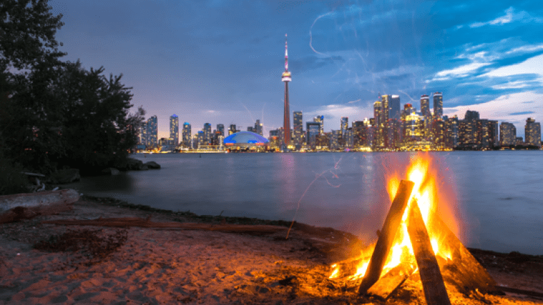 A bonfire in the front, the lake. CN Tower and the Toronto City skyline in the background
